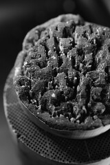 Used, destroyed, with deformation. Filter of harmful emissions, catalyst from the vehicle. detail close up view. Vertical photo. Muffler of the exhaust system. Black and white