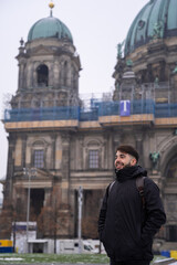 Fototapeta na wymiar Young male tourist with beard and berlin cathedral in the background
