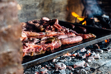 Barbeque, bbq meat cooking on grill. Traditional Asado of Argentina, Paraguay y Uruguay.