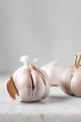Garlic bulb on a marble tray, garlic with a clove taken out, raw garlic, Allium sativum