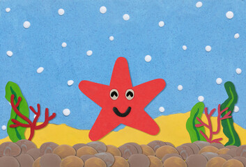 red star fish made from plasticine on under water background