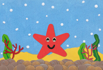 Fototapeta premium red star fish made from plasticine on under water background