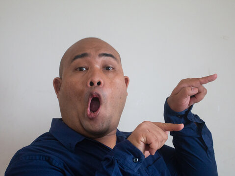 funny face bald fat asian man with point finger concept interesting on white background