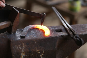 Blacksmith working at smithy workshop