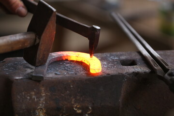 Blacksmith working at smithy workshop