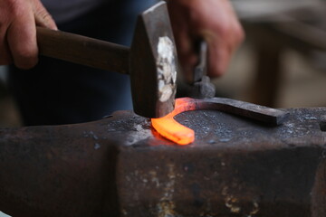 Blacksmith working at smithy workshop
