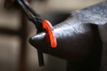 Blacksmith working at smithy workshop