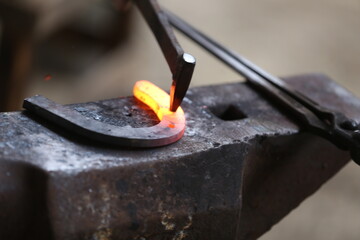 Blacksmith working at smithy workshop