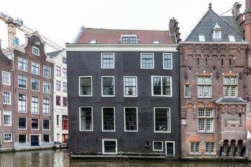 Fototapeta na wymiar Traditional brick houses on canal street in Amsterdam. Front view.