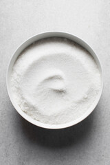 Top view of White sugar in a white bowl, granulated sugar for baking, white sugar in a mixing bowl