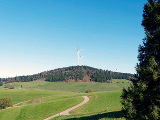 Fototapeta na wymiar Gersbach and Black Forest landscapes in Germany. Wind turbines on top of green hills surrounded by dense forests of the massif of Rohrenkopf 