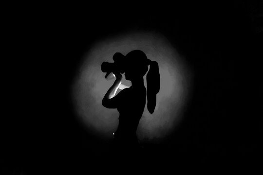 Center grey light silhouette on black background and lady photographer with camera taking photos. Concept of art photography. Dark picture at website, avatar, Surreal dark  abstract backdrop
