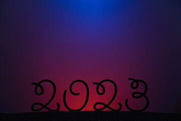 The date of the upcoming New Year 2023 on a color gradient background. A postcard with a New year's date and a gradient colored background.