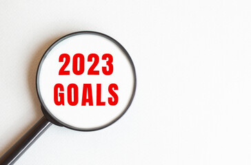 The text 2023 GOALS is written on a gray background. We read through a magnifying glass.