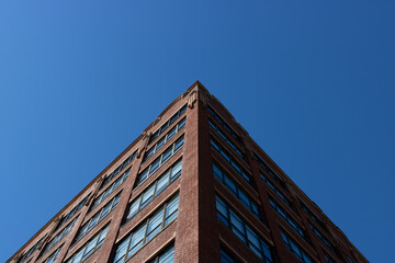 Fototapeta premium Building symmetry skyward view against natural blue sky gradient.