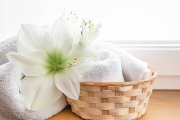 Fototapeta na wymiar Spa composition with lily flowers and towels in a basket.