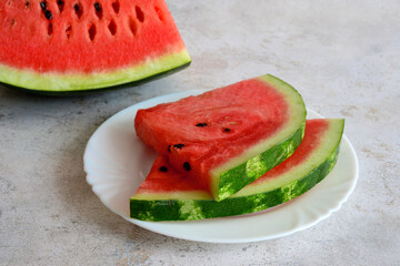 watermelon slices isolated on white plate on grey background, macro