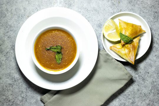 traditional bowl of spiced algerian vegetable soup named (Harira) and meat bourak named bourek