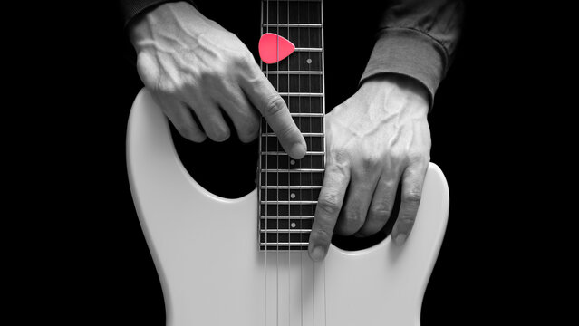 close up musician hands posing on white electric guitar, isolated on black. music background