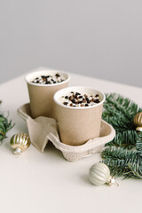 Obraz na płótnie Canvas Two small chocolate cakes in paper cups. Natural. Cake to go. Treat for New Year or Christmas