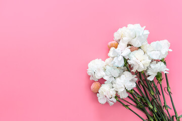 Bouquet of white carnations on a pink background isolated, flat lay.