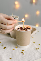 Two small cakes in paper cups. Natural. Cake to go. Woman lights candle on cake