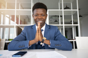 happy african businessman at table in office