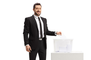 Professional man in a suit casting a vote in a ballot box and looking at the camera