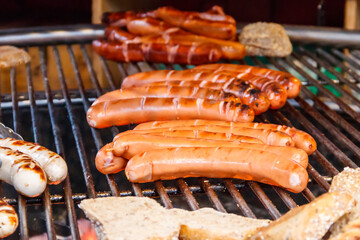 Grilling delicious juicy meat sausages on a big grill