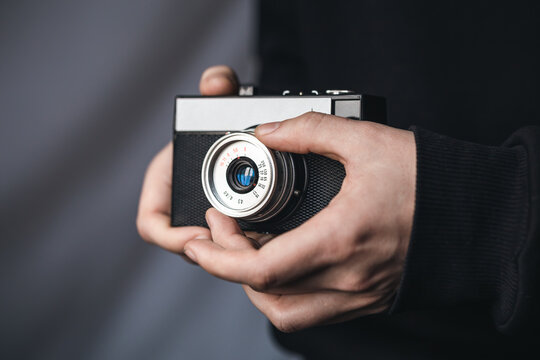 Close-up, film retro camera in male hands.