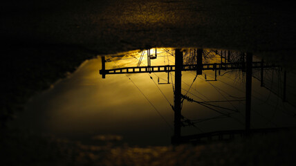 Train line in reflection of puddle