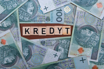 Fototapeta na wymiar Inscription Kredyt which meand debt next to polish money