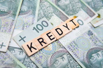 Inscription Kredyt which means debt in polish, next to money. Concept showing rising interest rates in Poland and high debt costs in Poland