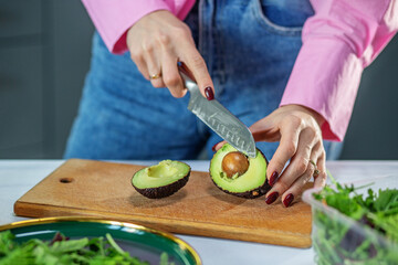 Hostess cuts vegetables and makes salad. Concept of eco-friendly products for cooking. Close up