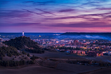 View of the city of Palencia at sunset next to the statue of Cristo del Otero