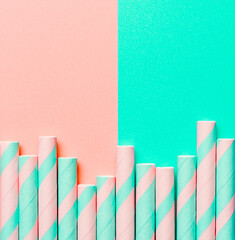 Striped paper straws on pink and blue background