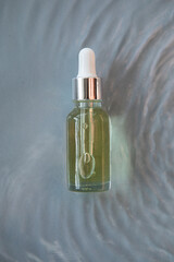 A bottle of serum in clear water with ripples.Mockup.