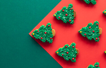 Christmas tree shaped gingerbread cookies covered with icing, flat lay.