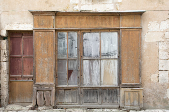 old retro abandoned wooden facade of an ancient worn wooden shop store brown in France Europe