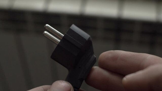 electric plug in the hands of a man