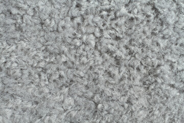 Light gray artificial curly fur texture. Macro. Closeup. Horizontal photo.