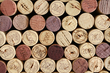 Cork wine bottle tops with numbers of years arranged tightly to each other.