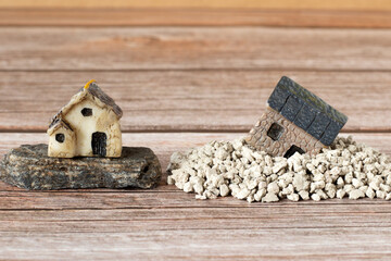 Two miniature houses in sand and on rock (stone). Copy space. A close-up. Solid foundation gospel...