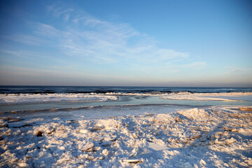 Fototapeta na wymiar Winter view on the icy sea coast and beautiful calm sky, selective focus