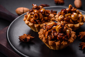 Sweet tasty tart with nuts and honey on a dark concrete background