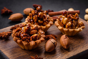 Sweet tasty tart with nuts and honey on a dark concrete background