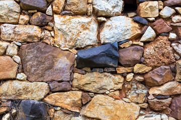 Ancient wall of rocks of different colors. Middle Ages wall.
