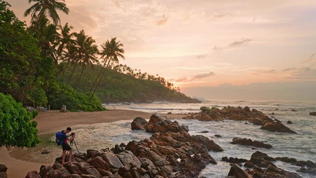 A professional photographer takes a photo of a tropical beach and ocean at dawn. Digital nomad. Tropical exotic nature
