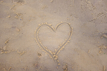 heart drawn in the sand on the beach