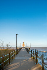 Naklejka premium horizontal photo of pier with lighthouse at sunset